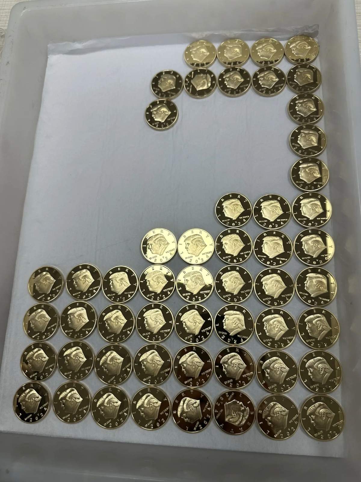 Hydraulically pressed gold commemorative coins arranged in production tray